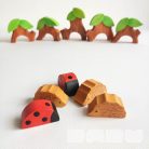 Tree trunk huts with leaf roofs and inhabitants – wooden toy